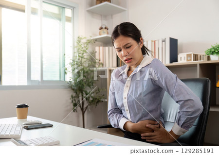 Office Syndrome: Woman in pain while working at her desk Office Syndrome: Woman in pain while working at her desk 129285191