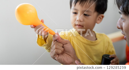 Halloween Fun: Child Handing Balloon to Father Halloween Fun: Child Handing Balloon to Father 129285239