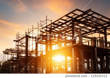 Construction site with steel frame at sunset. Ideal for architecture projects or building industry ads. Adds warm, industrial vibe to design portfolios. 129285312