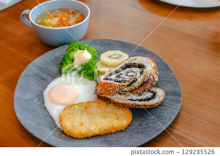 Western-style breakfast set featuring black sesame bread, hash browns, and a fried egg 129285526