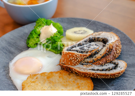 Western-style breakfast set featuring black sesame bread, hash browns, and a fried egg 129285527