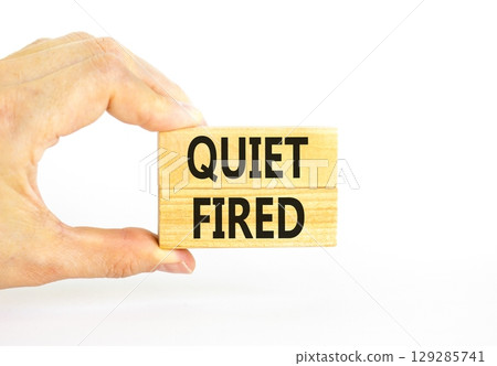 Quiet fired symbol. Concept words Quiet fired on wooden blocks. Beautiful white table white background. Businessman hand. Business and quiet fired concept. Copy space. 129285741