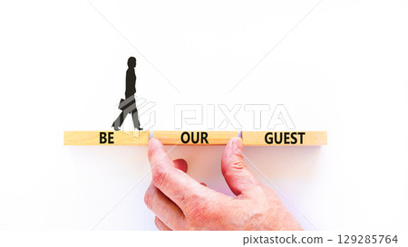 Be our guest symbol. Concept words Be our guest on beautiful wooden block. Businesswoman's icon. Beautiful white background. Business and be our guest concept. Copy space. 129285764
