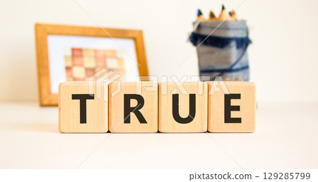 True symbol. Concept word True on beautiful wooden blocks. Beautiful picture frame and colored pencils. Beautiful white table white background. Business, lifestyle, support true concept. Copy space. True symbol. Concept word True on beautiful wooden blocks. Beautiful picture frame and colored pencils. Beautiful white table white background. Business, lifestyle, support true concept. Copy space. 129285799
