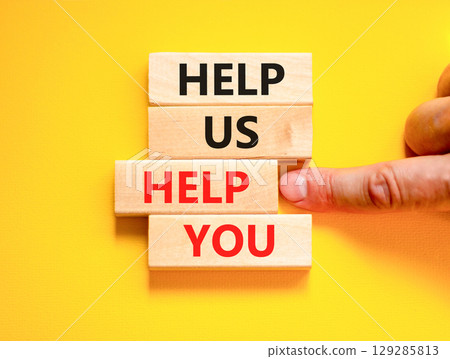 Help you symbol. Concept words phrase Help us help you on beautiful wooden blocks. Beautiful yellow paper background. Businessman's hand. Business Help you concept. Copy space. 129285813