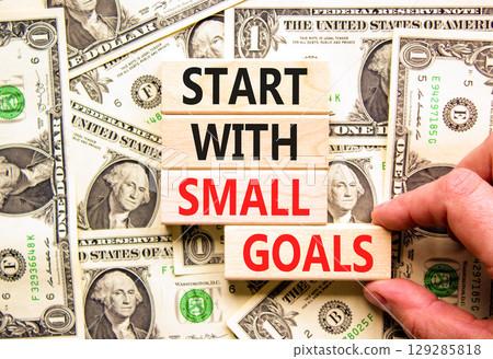 Start with small goals symbol. Concept words phrase Start with small goals on beautiful blocks. Dollar bills. Beautiful dollar bills background. Business Start with small goals concept. Copy space 129285818
