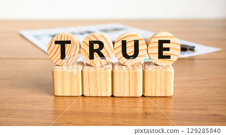 True symbol. Concept word True on beautiful wooden circles on wooden blocks. Beautiful wooden table white background. Business, lifestyle, support and true concept. Copy space. 129285840