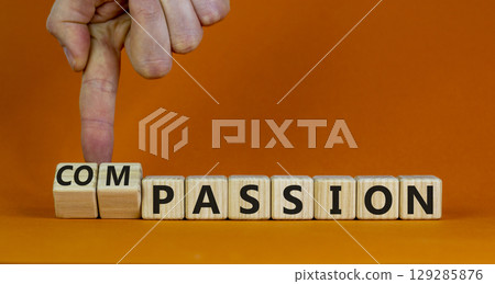 Passion or compassion symbol. Businessman turns cubes, changes the word compassion to passion. Beautiful orange table, orange background, copy space. Business, passion or compassion concept. 129285876