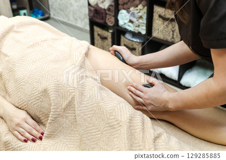 Female Massage Therapist Addressing Cellulite Issues on Women's Thighs, Legs, and Buttocks with Expertise 129285885