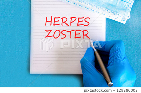 Herpes zoster symbol. Concept words Herpes zoster on beautiful white note. Doctor's hand in blue medical glove. Medical mask. Beautiful blue background. Medical healthy lifestyle herpes zoster concept Herpes zoster symbol. Concept words Herpes zoster on beautiful white note. Doctor's hand in blue medical glove. Medical mask. Beautiful blue background. Medical healthy lifestyle herpes zoster concept 129286002