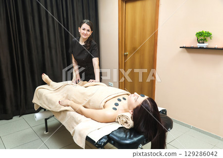 Female Massage Therapist Addressing Cellulite Issues on Women's Thighs, Legs, and Buttocks with Expertise 129286042