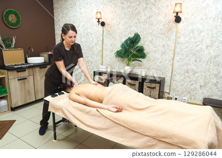 Relaxing Hot Stone Massage Therapy for Back and Neck Wellness, Promoting Relaxation and Healing 129286044