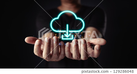 Data at your fingertips. Cloud computing is visualized with a glowing download icon above cupped hands, representing easy access and connectivity. 129286048