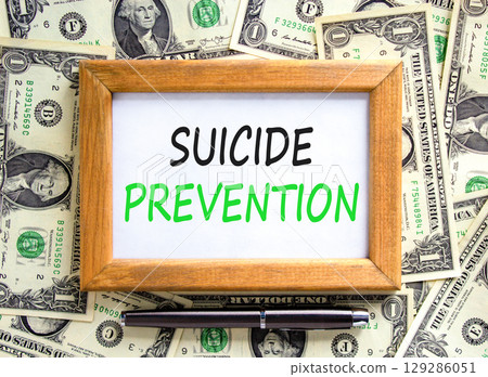 Suicide prevention symbol. Concept words Suicide prevention on beautiful wooden picture frame. Dollar bills. Beautiful background from dollar bills. Psychological suicide prevention concept Copy space 129286051