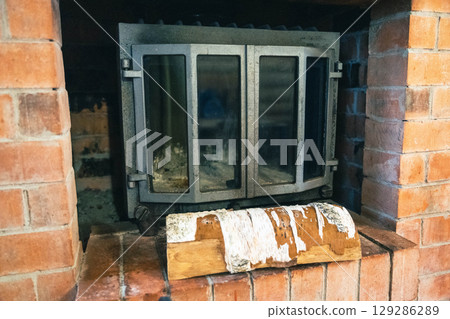 Rustic brick fireplace with wood log display 129286289