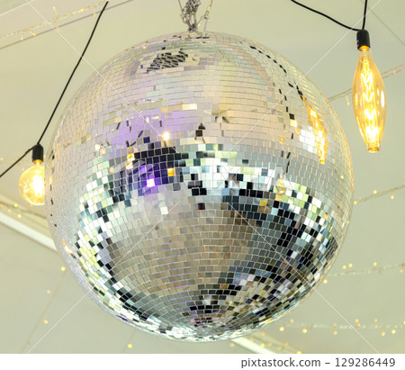 Disco ball in the light of the party. The magic of the mirror ball. 129286449