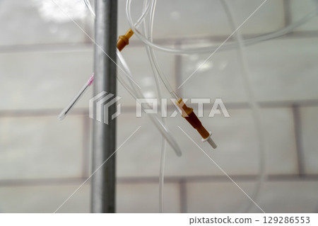 Iv drip hanging in hospital room delivering medicine 129286553