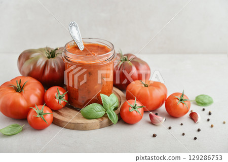 Traditional tomato sauce in a glass jar with fresh basil 129286753