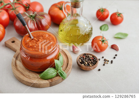 Traditional tomato sauce in a glass jar with fresh basil 129286765