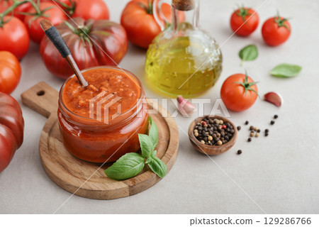 Traditional tomato sauce in a glass jar with fresh basil 129286766