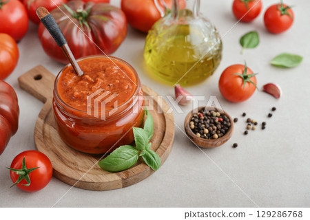 Traditional tomato sauce in a glass jar with fresh basil 129286768