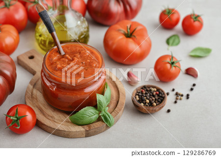 Traditional tomato sauce in a glass jar with fresh basil Traditional tomato sauce in a glass jar with fresh basil 129286769