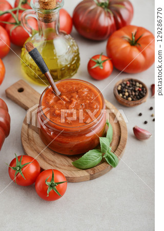 Traditional tomato sauce in a glass jar with fresh basil Traditional tomato sauce in a glass jar with fresh basil 129286770
