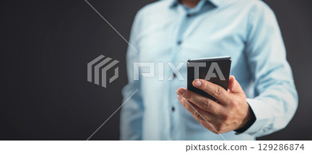 Businessman with phone receiving a message Businessman with phone receiving a message 129286874