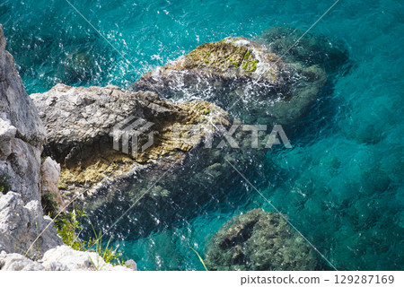 Stunning view of Calella de Palafrugell's pristine coastline featuring traditional whitewashed Mediterranean architecture, crystal-clear turquoise waters, and dramatic rocky outcrops along Costa Brava 129287169