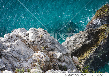 Stunning view of Calella de Palafrugell's pristine coastline featuring traditional whitewashed Mediterranean architecture, crystal-clear turquoise waters, and dramatic rocky outcrops along Costa Brava 129287215