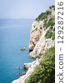Stunning view of Calella de Palafrugell's pristine coastline featuring traditional whitewashed Mediterranean architecture, crystal-clear turquoise waters, and dramatic rocky outcrops along Costa Brava 129287216