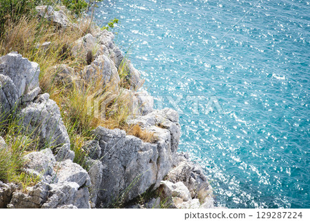 Stunning view of Calella de Palafrugell's pristine coastline featuring traditional whitewashed Mediterranean architecture, crystal-clear turquoise waters, and dramatic rocky outcrops along Costa Brava 129287224