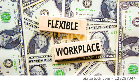 Flexible workplace symbol. Concept words Flexible workplace on beautiful wooden block. Beautiful dollar bills background. Dollar bills. Business Flexible workplace concept. Copy space. 129287344