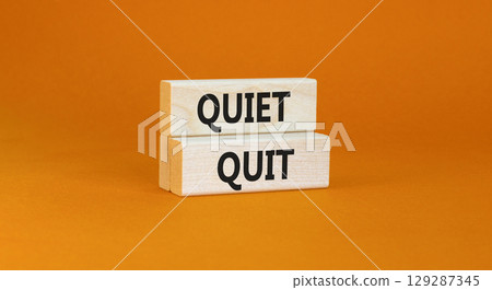 Quiet quit symbol. Concept words Quiet quit on wooden blocks. Beautiful orange table orange background. Business and quiet quit concept. Copy space. 129287345