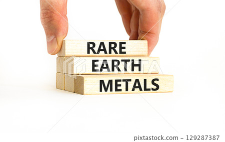 Rare earth metals symbol. Concept words Rare earth metals on beautiful wooden block. Businessman's hand. Beautiful white background. Business and rare earth metals concept. Copy space. 129287387