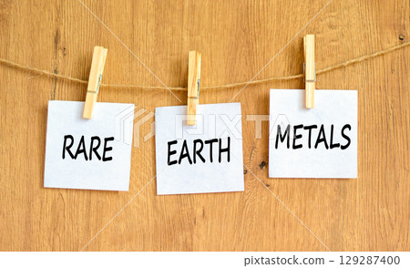 Rare earth metals symbol. Concept words Rare earth metals on beautiful white paper on wooden clothespin. Beautiful wooden background. Business and rare earth metals concept. Copy space. 129287400