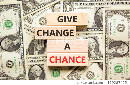 Give change a chance symbol. Concept words phrase Give change a chance on beautiful wooden blocks. Dollar bills. Beautiful dollar bills background. Business Give change a chance concept. Copy space. 129287425