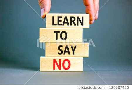 Learn to say no symbol. Concept words phrase Learn to say no on beautiful wooden blocks. Beautiful grey paper background. Businessman's hand. Business psychological Learn to say no concept. Copy space 129287430