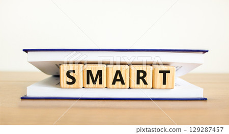 Smart symbol. Concept word Smart on beautiful wooden blocks in book. Beautiful wooden table white background. Business lifestyle smart concept. Copy space. 129287457