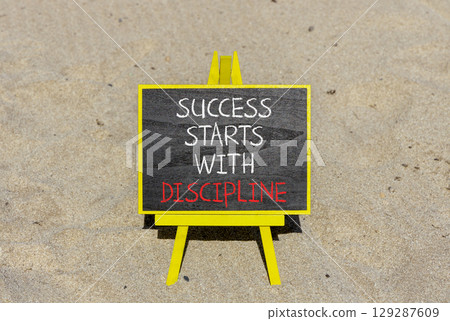 Success starts with discipline symbol. Concept words Success starts with discipline on beautiful blackboard. Beautiful sand background. Business success starts with discipline concept. Copy space 129287609