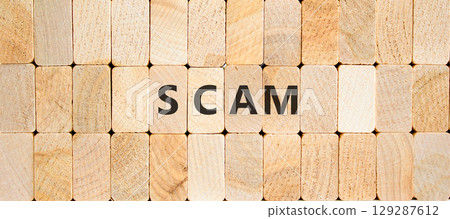 Scam symbol. Concept word Scam on beautiful wooden blocks. Beautiful wooden blocks background. Business, lifestyle, support and scam concept. Copy space. 129287612