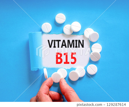 Vitamin B15 pantothenic acid symbol. Concept words Vitamin B15 on beautiful white paper. White pills tablets. Doctor's hand. Beautiful blue background. Medical healthy lifestyle Vitamin B15 concept. 129287614