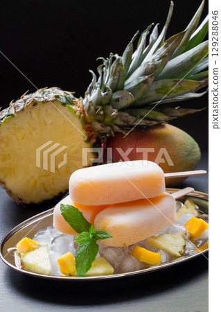 Enjoy a delicious treat featuring mango pineapple ice cream placed atop ice with chunks of fresh pineapple. Garnished with mint, this dessert exudes summer vibes. Enjoy a delicious treat featuring mango pineapple ice cream placed atop ice with chunks of fresh pineapple. Garnished with mint, this dessert exudes summer vibes. 129288046