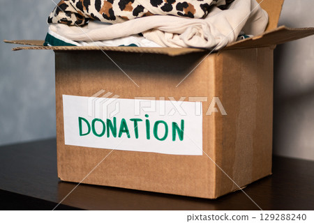 Woman gives her old clothes to charity, helping people in need who are caught up in military action. Woman gives her old clothes to charity, helping people in need who are caught up in military action. 129288240
