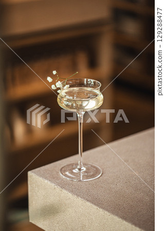 Elegant cocktail in glass with flower on bar ledge 129288477