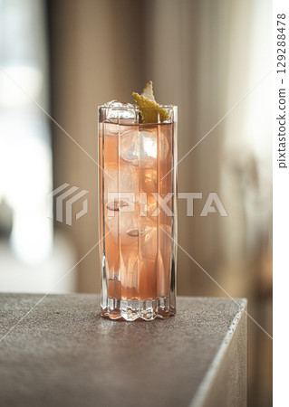 Pink cocktail in tall glass with lemon and ice Pink cocktail in tall glass with lemon and ice 129288478