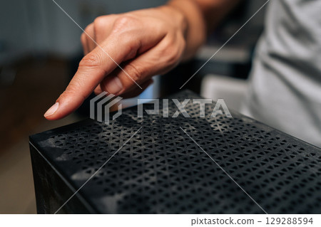 Technician finger pointing at dust accumulation on computer case surface, emphasizing importance of regular cleaning and maintenance for optimal performance. Concept of service, repair, cleaning PC. 129288594