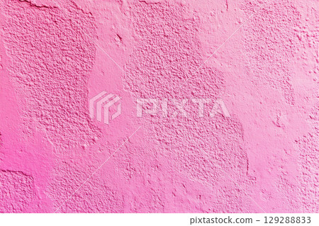A close-up of a weathered, cracked wall with peeling paint, showing a textured surface in various shades of pink and light purple. A close-up of a weathered, cracked wall with peeling paint, showing a textured surface in various shades of pink and light purple. 129288833