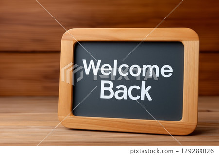 A small wooden-framed sign with "Welcome Back" in white text on a blackboard surface. 129289026