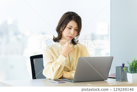 Woman/businesswoman thinking while using a computer Woman/businesswoman thinking while using a computer 129289146